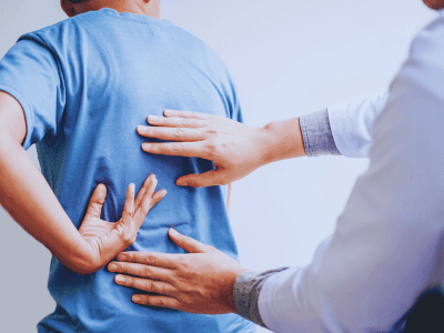 Chiropractor assessing lower back pain treatment