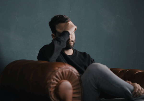 A man holding his forehead, experiencing a headache assessed at Farrelly Chiropractic Narre Warren