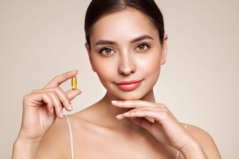 close up of happy beautiful woman with a fish oil pill