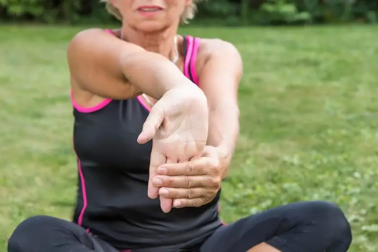 Senior Woman Is Showing Exercise For Pain Relief. Forearm Stretching For Carpal Tunnel Syndrome Pain